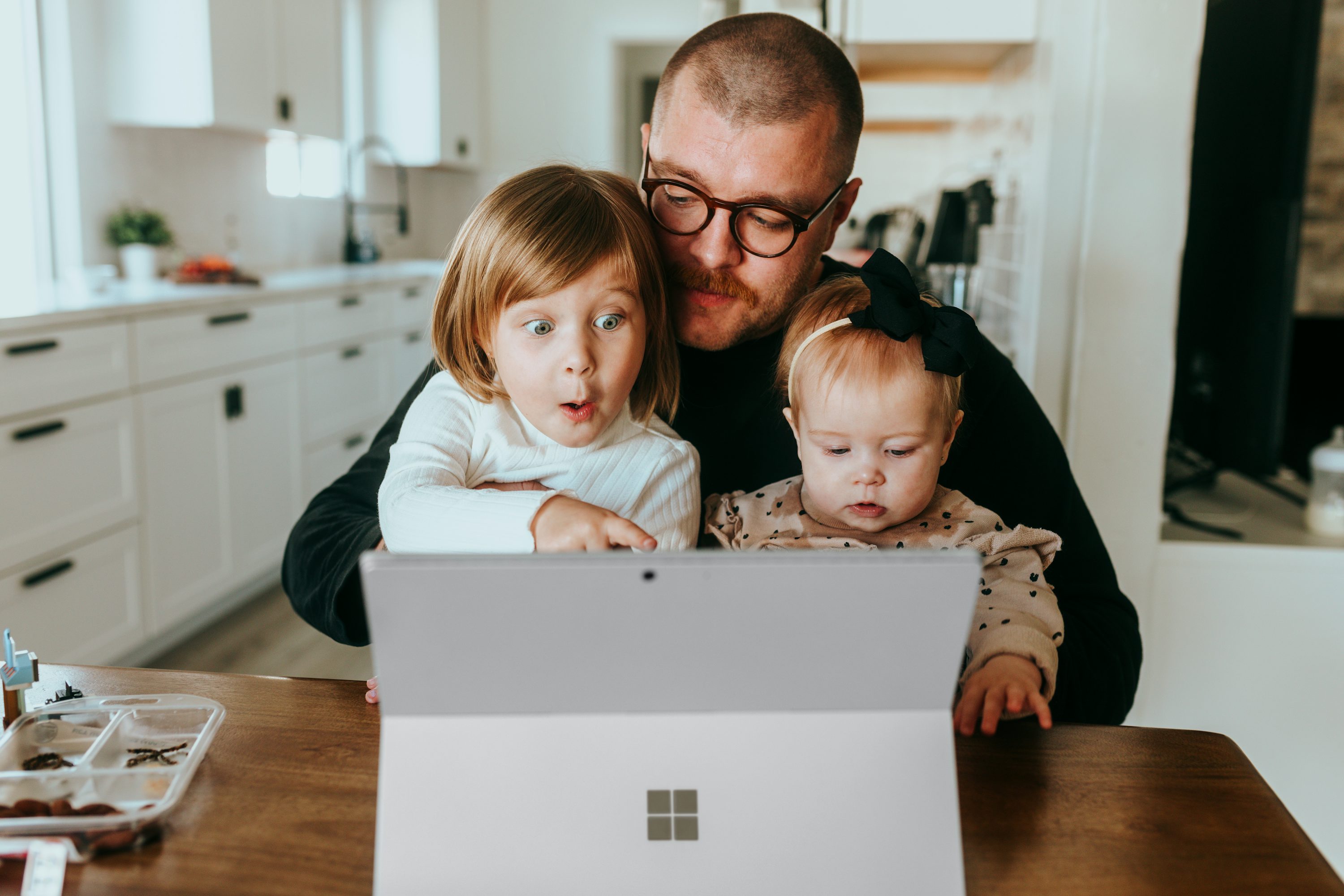 A parent and children using a laptop together at home